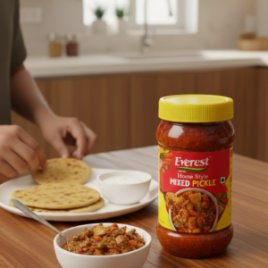 Everest Home Style Mixed Pickle jar placed on dining table with paratha, curd, and a bowl of mixed achar.